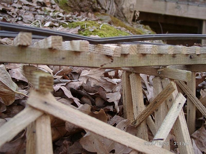 200512231517b.JPG - Another view of the damage. As of 3 January 2006 the trestle has been repaired and the rail is in place but still needs to be spiked down.